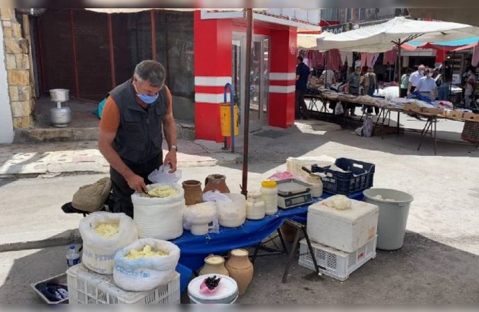 Üç dil bilen rehber, pazarda peynir satıyor